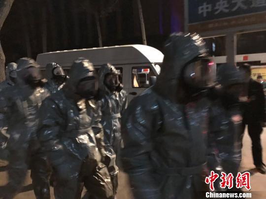 十几名身着防护服的人员头戴面具进入事发地。　胡健 摄